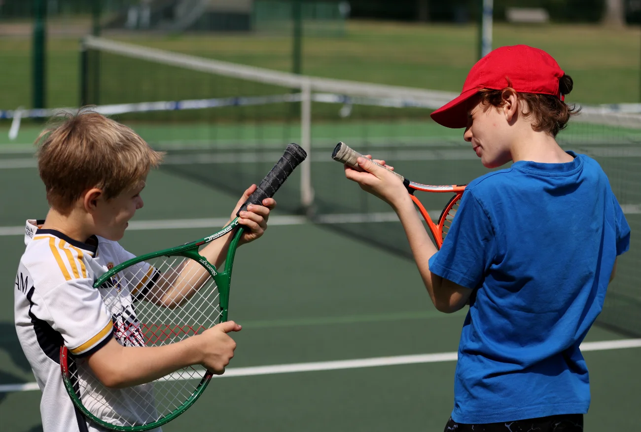 Boys pretending to play tennis rackets like guitars.