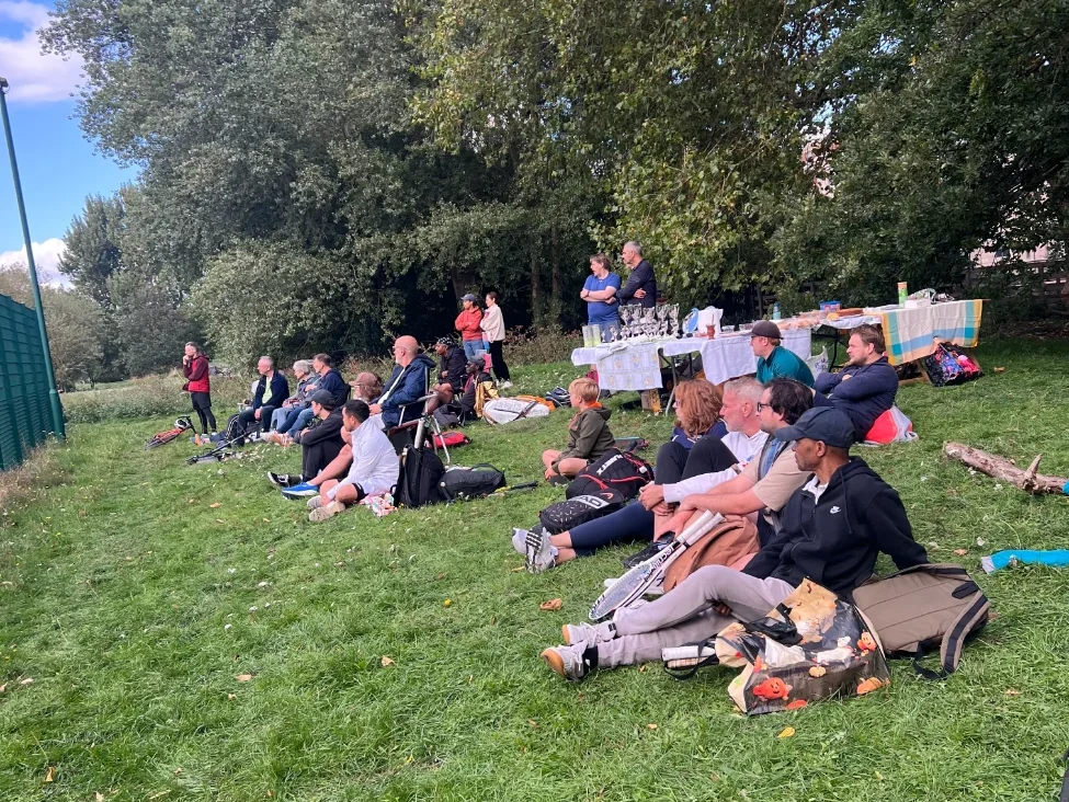 A group of spectators on a grassy bank .