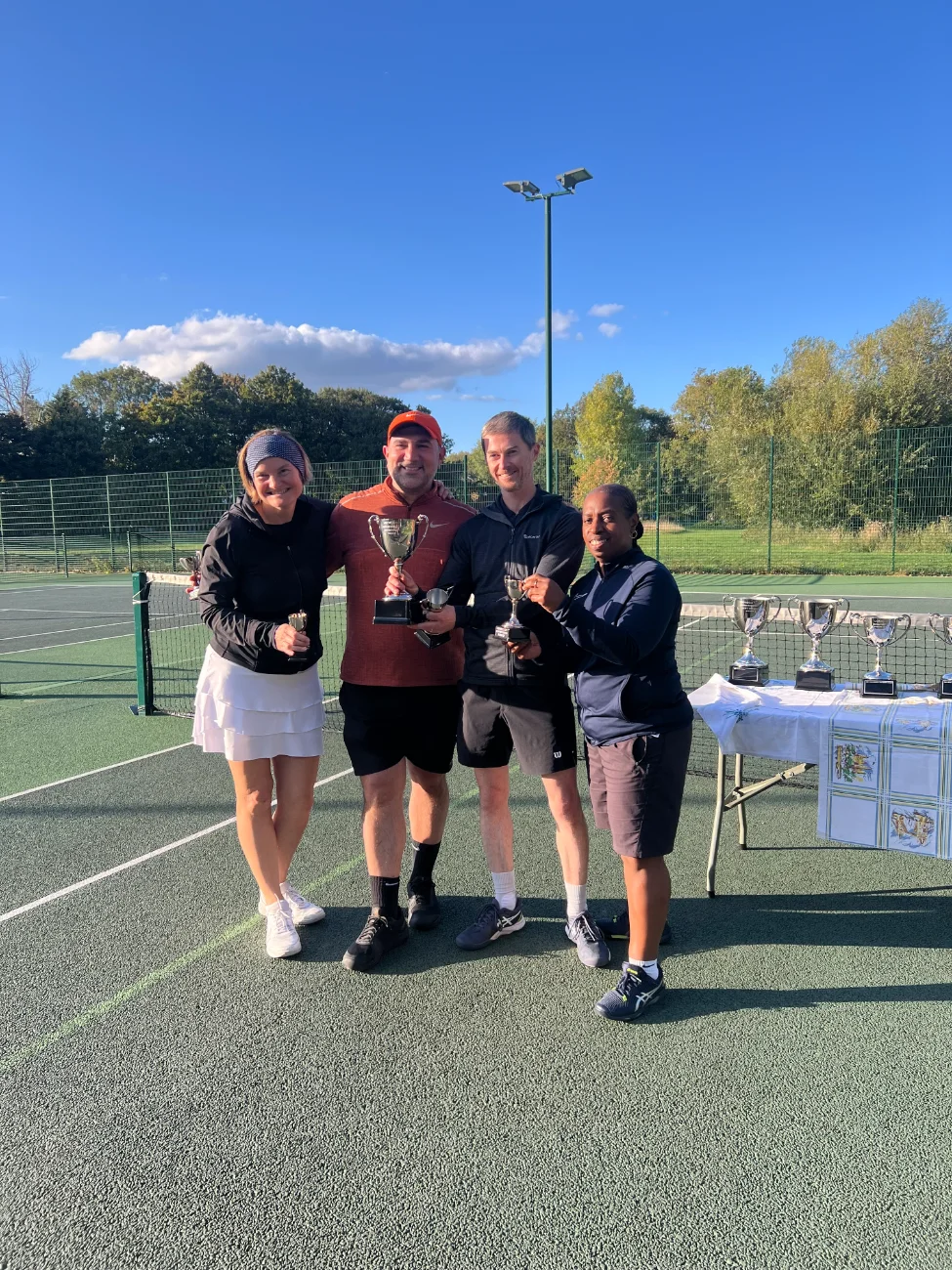Four mixed doubles players showing off their trophies.